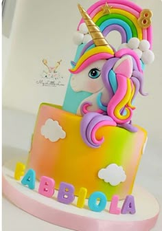 a birthday cake with a rainbow unicorn on top