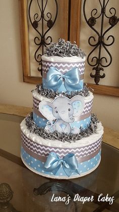 a three tiered baby shower cake with an elephant on top