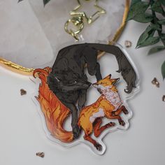 an animal keychain with two foxes on it's front and one fox on the back