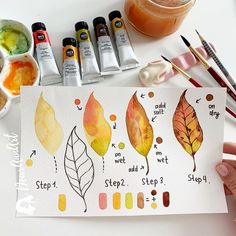 someone is painting leaves with watercolors on paper