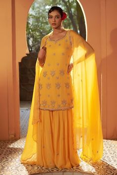 Yellow kurta with floral resham cutdana, sequin, and zari embroidery. Paired with a sharara and dupatta with embroidered border. - Aza Fashions Embellished Yellow Sharara For Eid, Yellow Embellished Sharara With Traditional Drape, Yellow Embellished Palazzo Set For Weddings, Embellished Yellow Sharara For Diwali, Elegant Yellow Palazzo Set With Mirror Work, Diwali Yellow Embellished Sharara, Yellow Embellished Sharara For Wedding, Embellished Yellow Sharara For Wedding, Yellow Embellished Semi-stitched Sharara