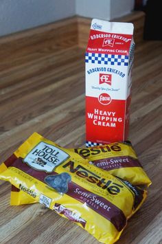 two bags of ice cream sitting on top of a wooden table next to a box