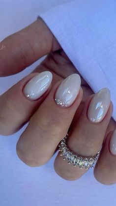 a woman's hand with white manies and some diamonds on her nails,