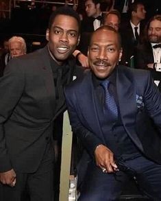 two men sitting next to each other at an event