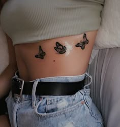 a woman's stomach with three butterflies on her side, and the bottom part of her abdomen