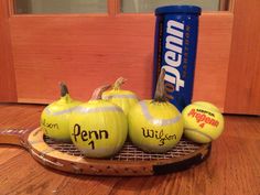 three tennis balls on a racket next to a can of pennn's