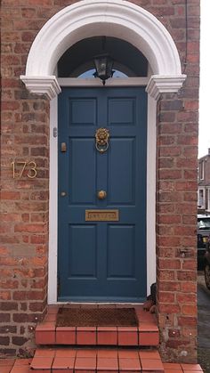 a blue front door with brick steps leading up to it