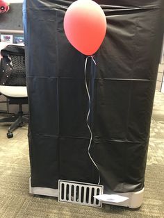 a balloon is attached to the back of an office chair with a black cover over it