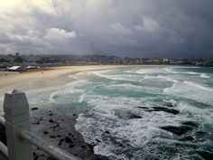 the ocean is very choppy and blue with waves coming in from the shore line