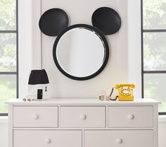 a white dresser topped with a mirror and mickey mouse head