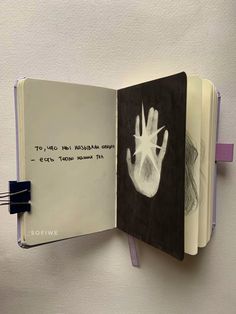 an open book with a hand drawn on it