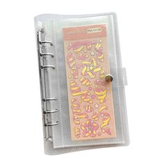 a small clear book with pink and yellow letters on it's front cover is shown