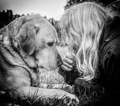 a woman is petting a large dog on the nose in black and white photo