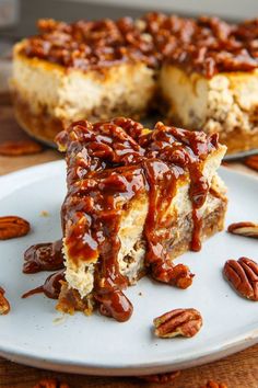 a piece of pecan cheesecake on a white plate with pecans around it