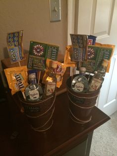 two buckets filled with liquor and snacks on top of a wooden table next to a door