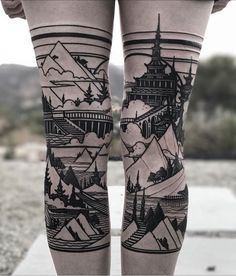 a woman's legs with tattoos on them, and mountains in the sky behind her