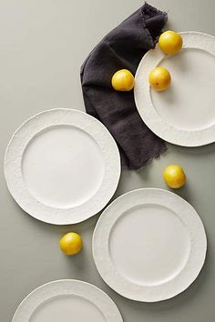 three white plates with lemons on them