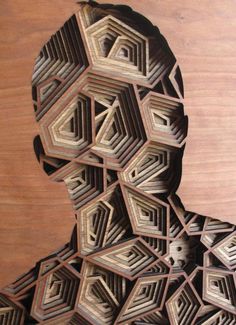 an intricate wooden sculpture is displayed on a table with wood grains in the shape of hexagonal shapes