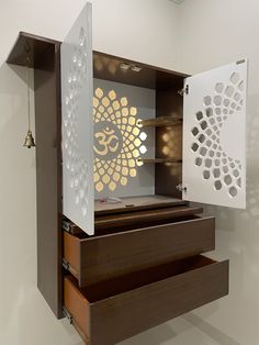 an open cabinet with the door and drawers opened to reveal a design on the wall