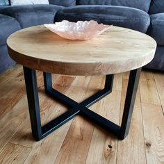 a wooden table sitting on top of a hard wood floor next to a blue couch