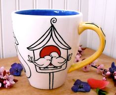 a coffee cup with a drawing of a couple kissing in a tent on the table