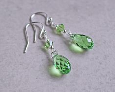 "Peridot green crystal teardrop earrings are made with peridot crystal teardrops accented with silver or gold beads. They dangle 1\" from sterling silver or gold fill ear wires. Peridot is the birth crystal for August. ❖ Crystal Passions crystals ❖ silver or gold fill beads ❖ .925 sterling silver or 14k gold fill ear wires Earrings shown are on french hook ear wires. All earring types are sterling silver or gold fill with the exception of clip-ons, which are silver or gold plated." Teardrop Beaded Earrings, Briolette Earrings, Diy Earrings Dangle, Anting Manik, Diy Earrings Easy, Hummingbird Earrings, Wire Jewelry Earrings, Crystal Teardrop Earrings, Peridot Crystal