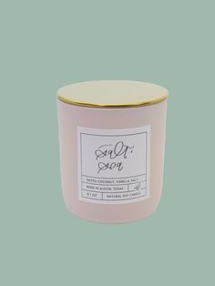 a pink candle with a gold lid and label on it that says, sold out