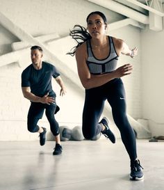 two people are running and one is holding a frisbee