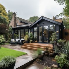 a house that has some plants in the front yard and steps leading up to it