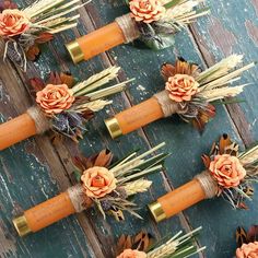 several orange candles with flowers on them sitting on top of a wooden table next to each other