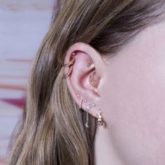 a close up of a person with ear piercings on their ears and behind the ear