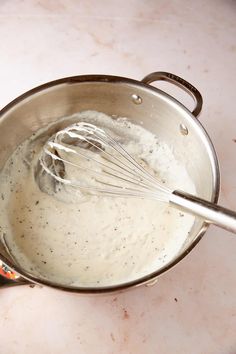 a metal pan filled with batter and whisk on top of a countertop