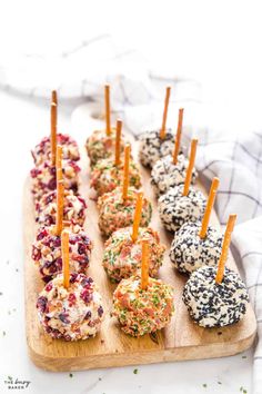 an assortment of appetizers are arranged on a cutting board with toothpicks