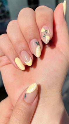 a woman's hand with yellow and white nail polish