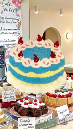 a table topped with cakes and desserts covered in frosting