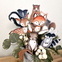 a vase filled with fake animals sitting on top of a table