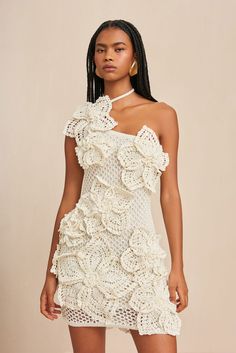 A hand-crocheted, mini-dress with large, three-dimensional knit floral motifs.- Ties behind the neck- Lined- Open knit- One shoulder