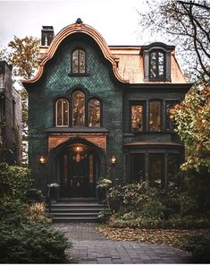 an old victorian style house with lots of windows and brick walkway leading up to the front door