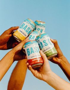 several people are holding cans of food in their hands against a blue sky with the word basalk written on it