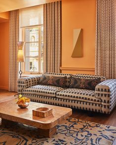 a living room filled with furniture and orange walls