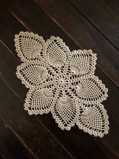 white doily on wooden floor with dark background