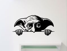 a black and white wall decal with an animal's head peeking over the edge