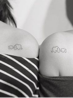 two women with small tattoos on their backs, one has an elephant and the other has a bear