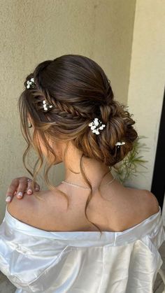 a woman wearing a white dress with flowers in her hair