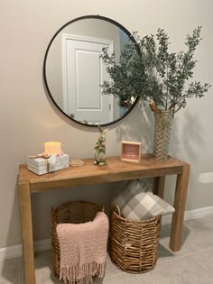 a wooden table topped with a mirror next to a basket