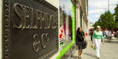 two women walking down the sidewalk in front of a sign for sterling & co, inc