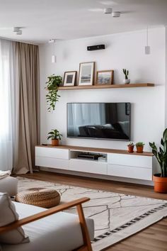 a living room filled with furniture and a flat screen tv on top of a wooden shelf