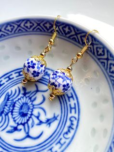 Pretty Floral Porcelain Earrings, Oriental Earrings, Victorian Jewellery, Delft Blue, Handmade UK Oriental themed porcelain floral earrings in the colour of pretty blue flowers on white background.To capture each of the round flower bead, I have decorated the beads with gold plated scallop filigree to gives it a warm contrasting finish. Care: In order to keep your jewellery in perfect condition, we always advice keeping items out of contact with any chemicals, strong perfume or water. Packaging: Gold Flower Earrings With Round Beads For Gift, Gift Pearl Earrings With Round Beads, Gold Round Beads Flower Earrings As Gift, Handmade Blue Pearl Earrings For Gift, Traditional Blue Filigree Earrings, Elegant Flower Earrings With Round Beads As Gift, Traditional Flower Earrings With Ear Wire As Gift, Elegant Round Beads Flower Earrings As Gift, Blue Round Plug Earrings For Gift