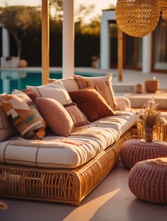 a couch and ottoman sitting on top of a patio next to an outdoor swimming pool