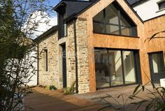 a house made out of wood and stone with an open porch area next to it